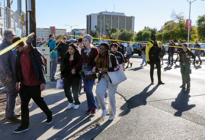 LAS VEGAS, NEVADA - DECEMBER 06: People cross Maryland Parkway as they are led off of the UNLV campus after a shooting on December 06, 2023 in Las Vegas, Nevada. According to Las Vegas Metro Police, a suspect is dead and multiple victims are reported after a shooting on the campus. (Photo by Ethan Miller/Getty Images)
