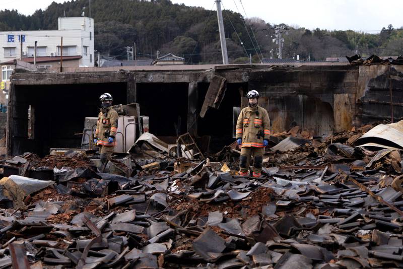 WAJIMA, JAPAN - JANUARY 05: Firefighters stand on debris in the aftermath of an earthquake on January 05, 2024 in Wajima, Japan. On New Year's Day, a series of major earthquakes reportedly killed at least 92 people, injured dozens more and destroyed a large amount of homes. The earthquakes, the biggest measuring 7.1 magnitude, hit the areas around Ishikawa, Toyama and Niigata in central Japan. (Photo by Tomohiro Ohsumi/Getty Images)