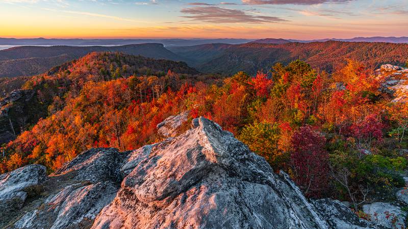 Oct. 26, 2023: Golden hues of sunrise brighten fall foliage in the Linville Gorge, as seen in this image taken from The Chimneys near Table Rock.
