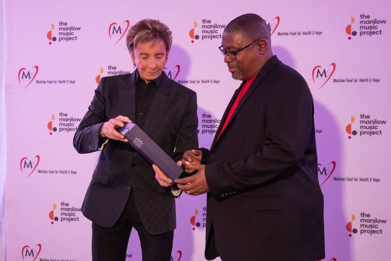 Singer Barry Manilow presents Walter Suggs of Phillip O Berry Academy of Technology High School with The Manilow Music Project Music Teacher Award in Charlotte.  Suggs received $5,000 cash and another $5,000 in “Manilow bucks” to purchase musical instruments for his school’s music program.