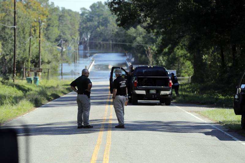Responders congregate Wednesday, Sept. 19, 2018 near where two people drowned Tuesday evening when they were trapped in a Horry County Sheriff transport van while crossing an overtopped bridge over the Little Pee Dee River on Hwy 76, during rising floodwaters in the aftermath of Hurricane Florence in Marion County, S.C.