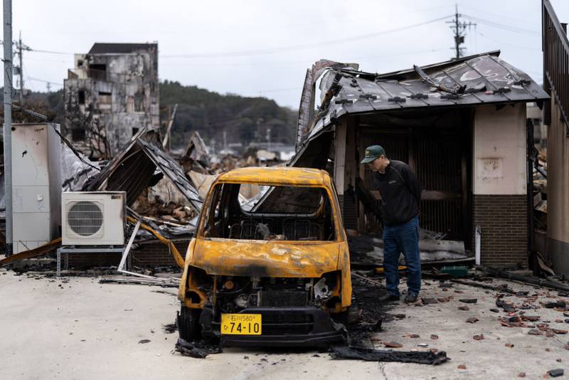 WAJIMA, JAPAN - JANUARY 05: A man looks at his damaged vehicle in the aftermath of an earthquake on New Year's Day on January 05, 2024 in Wajima, Japan. A series of major earthquakes have reportedly killed at least 92 people, injured dozens more and destroyed a large amount of homes. The earthquakes, the biggest measuring 7.1 magnitude, hit the areas around Ishikawa, Toyama and Niigata in central Japan on Monday. (Photo by Tomohiro Ohsumi/Getty Images)