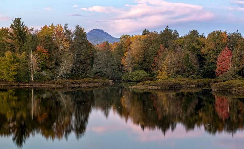 Fall color is reflected in the lake at Camp Yonahnoka near Linville, N.C., as Grandfather Mountain rises in the distance.
