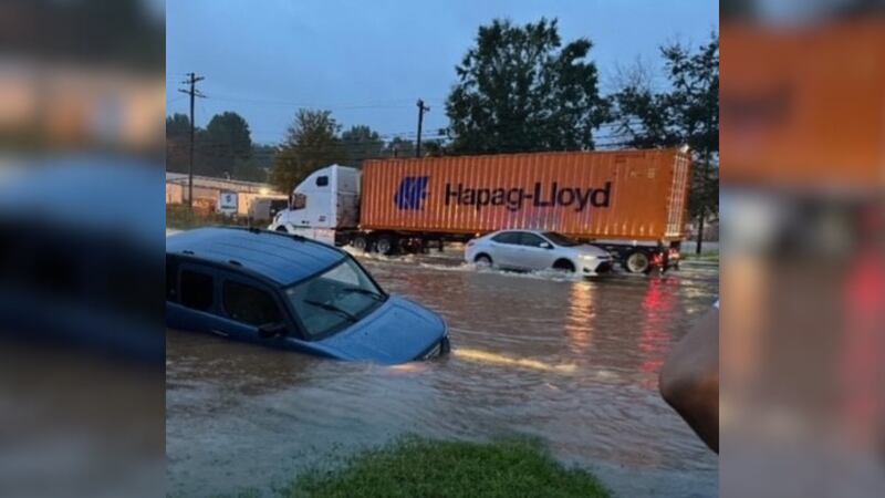 A car gets stuck in floodwaters on the side of Wilkinson Boulevard in west Charlotte on Aug. 8, 2024.