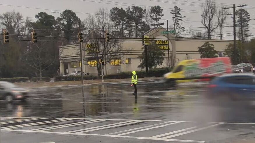 CMPD officer directs traffic as rain falls in Charlotte on Dec. 2, 2025