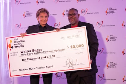 Singer Barry Manilow presents Walter Suggs of Phillip O Berry Academy of Technology High School with The Manilow Music Project Music Teacher Award in Charlotte.  Suggs received $5,000 cash and another $5,000 in “Manilow bucks” to purchase musical instruments for his school’s music program.