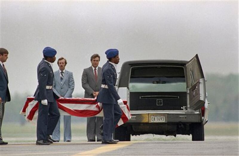 The remains of one crewmembers of the Space Shuttle Challenger are carried to a hearse on the tarmac at Dover Air Force Base in Dover, Delaware on Tuesday, April 30, 1986. The remains of all seven astronauts killed in the Shuttle explosion on January 28, were taken to Dover AFB for burial preparation. (AP Photo/Amy Sancetta)