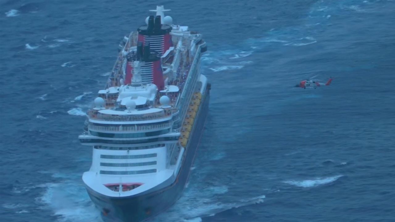 Disney Fantasy with a Coast Guard helicopter flying nearby.