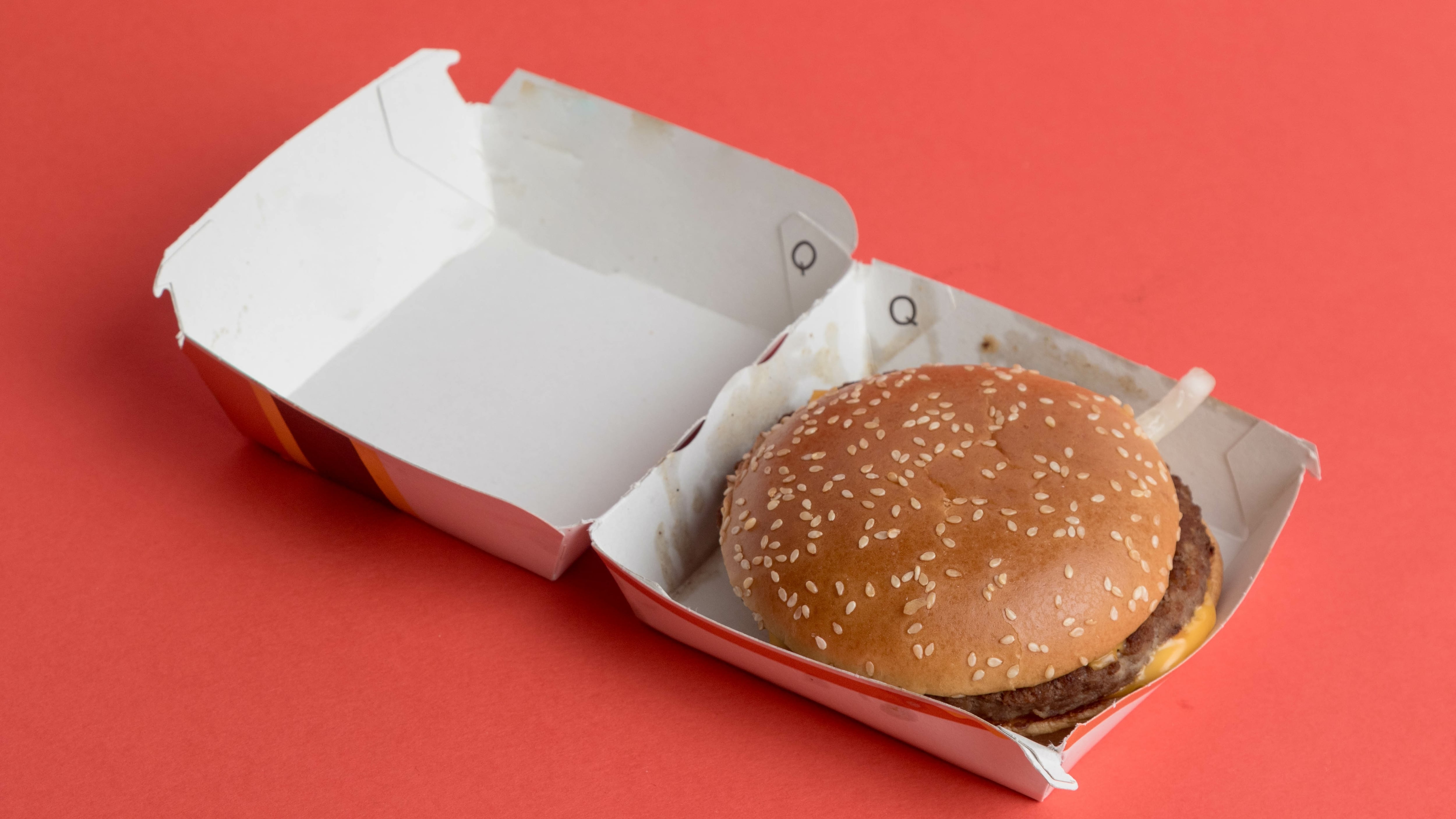 A view of a McDonalds Quarter Pounder With Cheese, against a red background