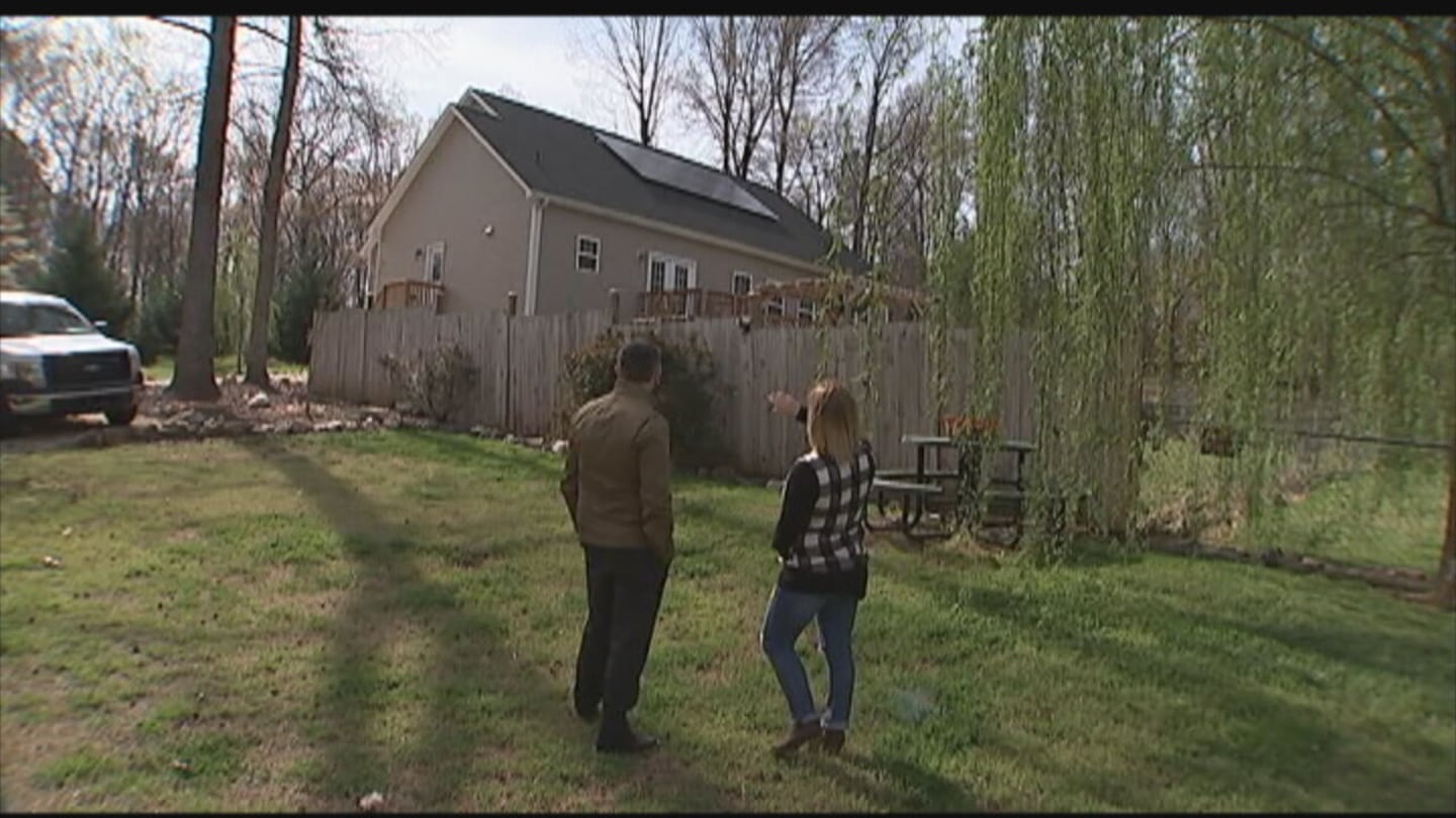 Becky Herrington shows Jason Stoogenke the solar panels on her roof.