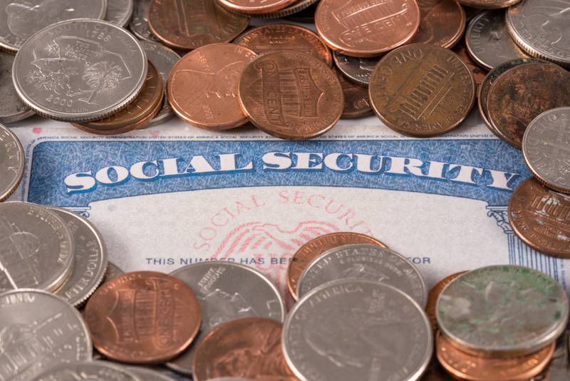 USA social security card with coins and cash to show funding crisis in the trust fund