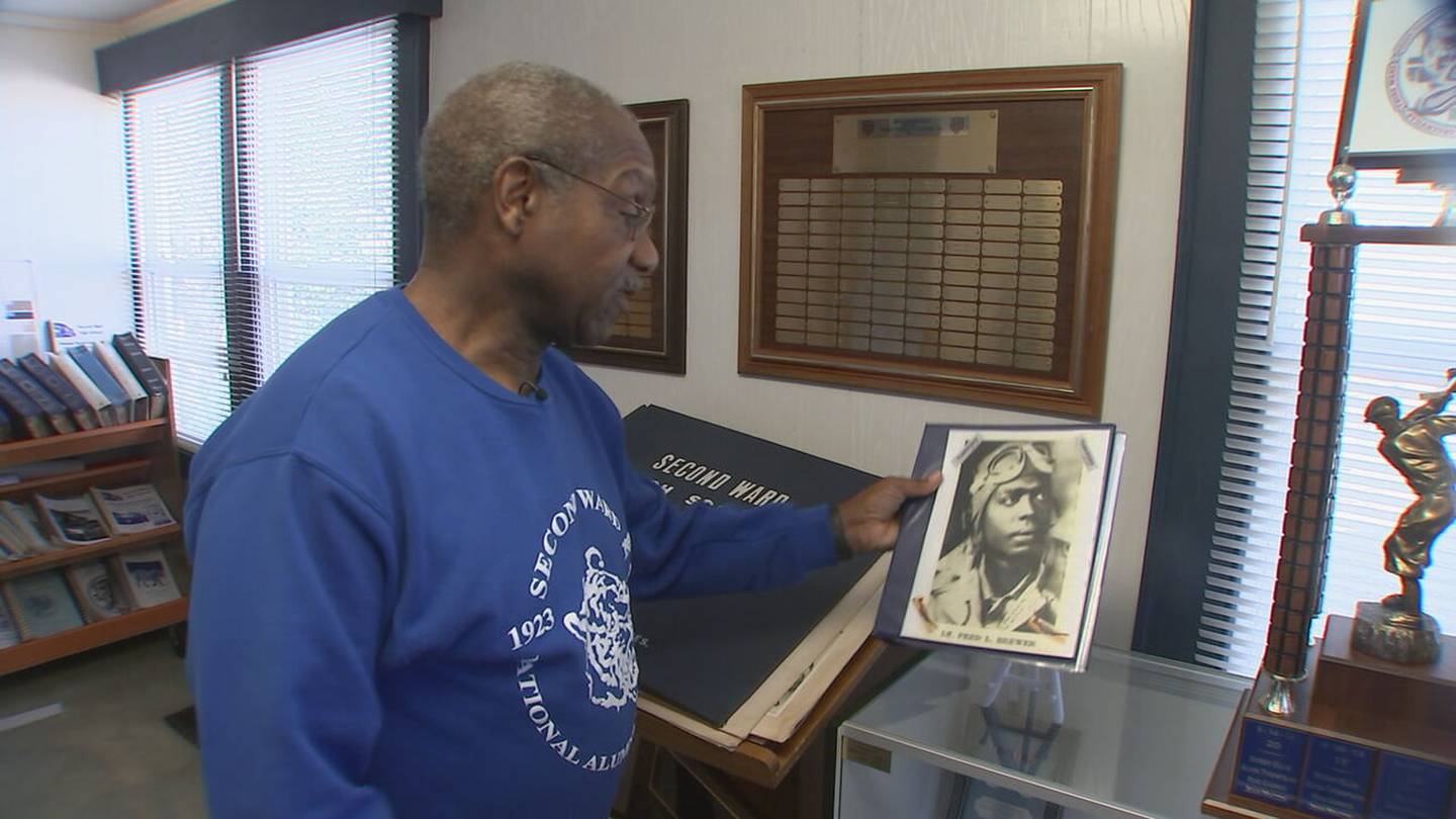 Arthur Griffin holds a picture of Lt. Fred Brewer Jr., a graduate of Second Ward High School and Tuskegee Airman.